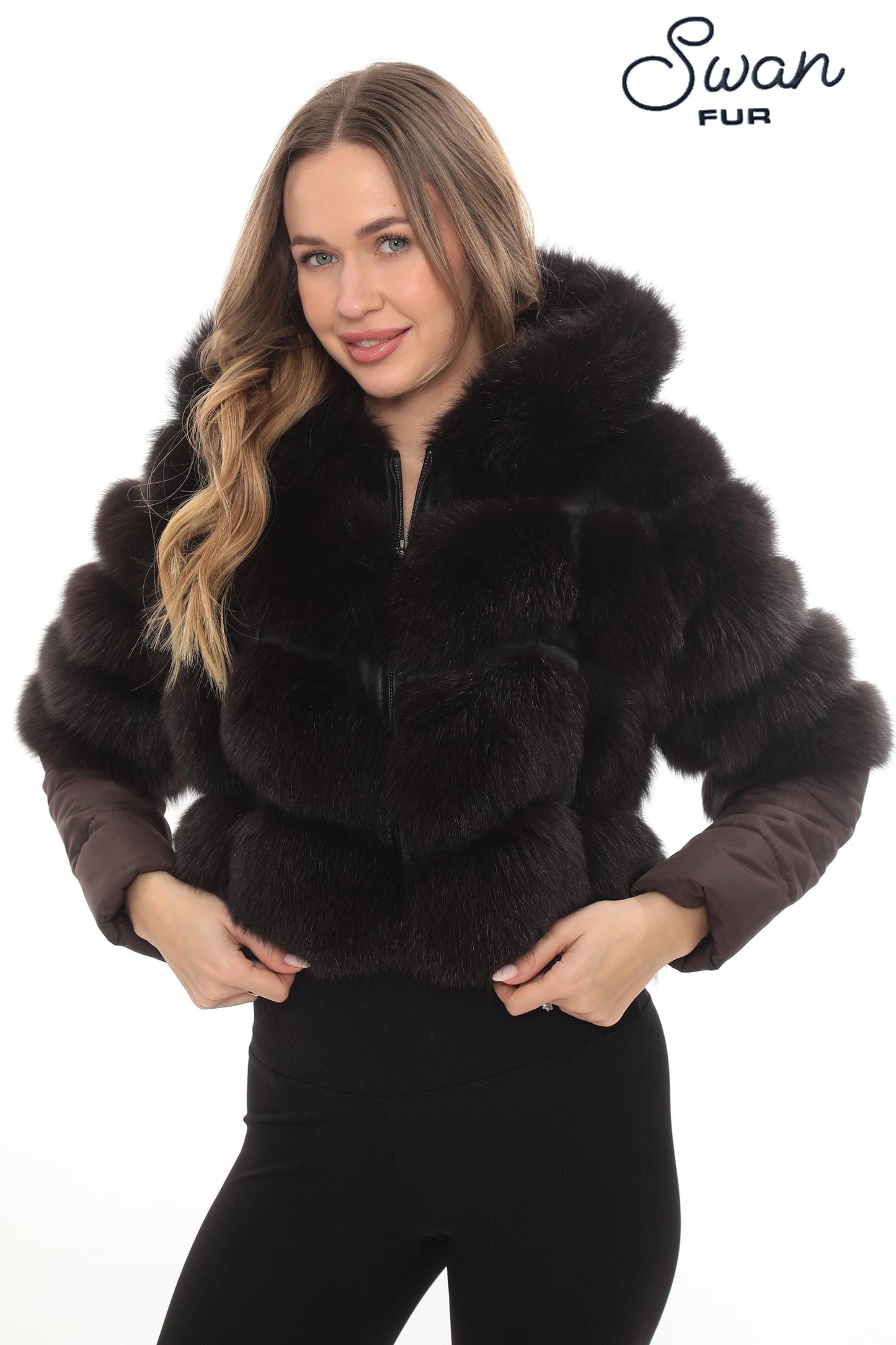 May include: A dark brown fur jacket with a hood and brown sleeves. The jacket has a zipper closure and is worn by a person. The Swan Fur logo is visible in the upper right corner.